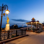 Beautiful view of Shimla with colonial buildings, green hills, pine forests, and scenic Himalayan mountain landscapes under a clear blue sky.