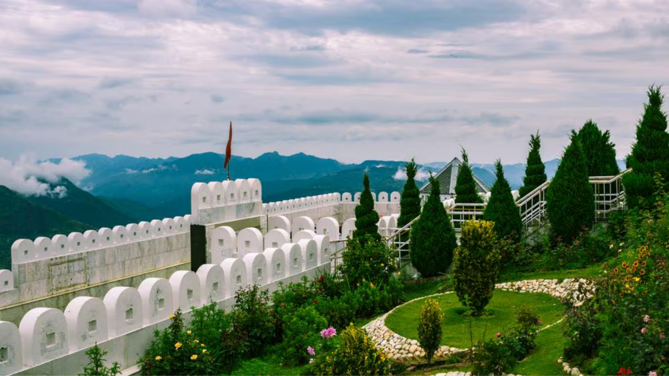 Beautiful landscape of Chail featuring lush green hills, dense pine forests, scenic mountain views, and peaceful surroundings under a clear blue sky.