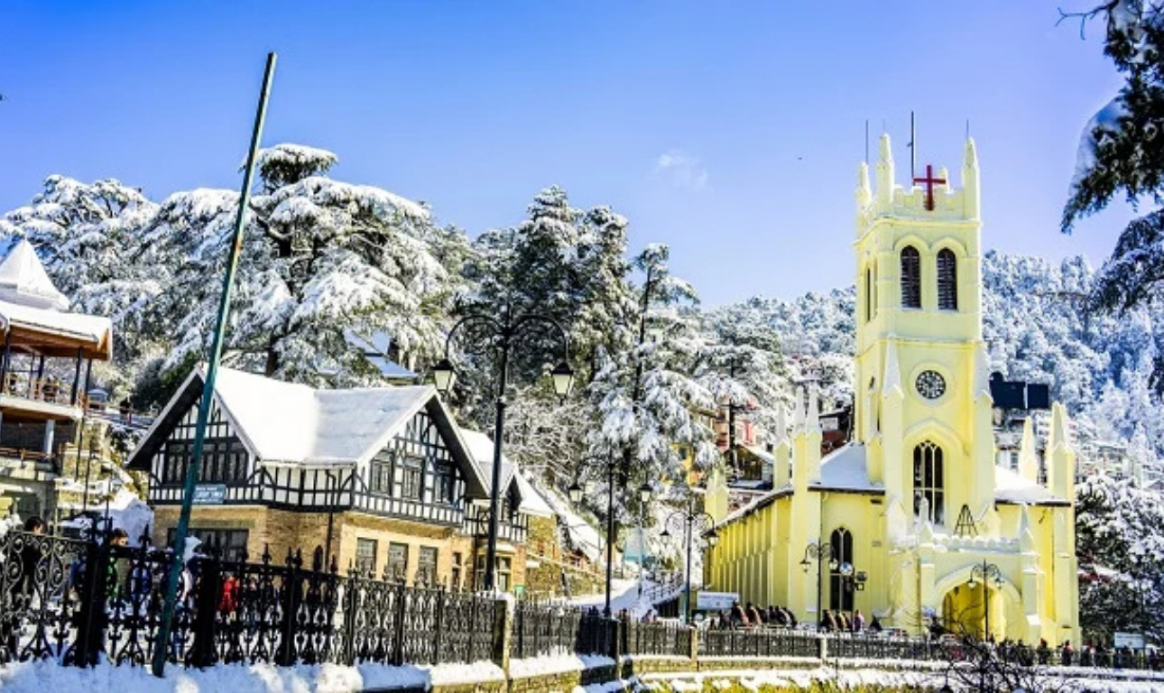 Snow-covered hill station in India featuring a beautiful church, winter landscape, pine trees, and charming buildings during snowfall.