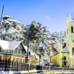 Snow-covered hill station in India featuring a beautiful church, winter landscape, pine trees, and charming buildings during snowfall.