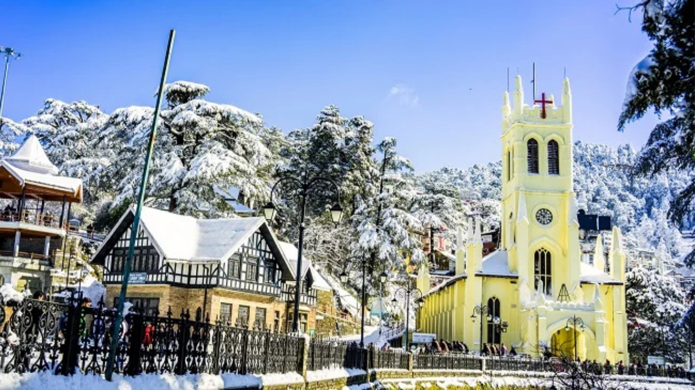 Snow-covered hill station in India featuring a beautiful church, winter landscape, pine trees, and charming buildings during snowfall.
