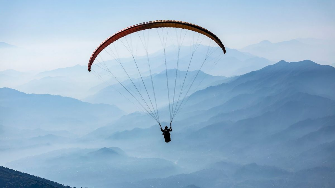Paragliding adventure over the scenic mountain valleys of Bir Billing with breathtaking views of the Himalayas.