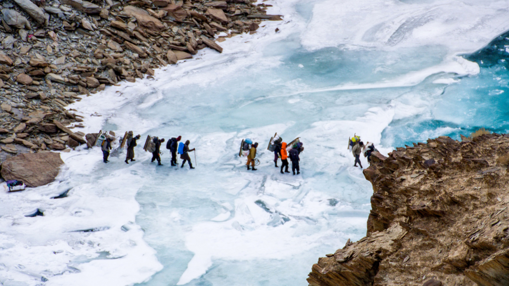 Trekkers walking on the frozen Zanskar River during the Chadar Trek in Ladakh, India