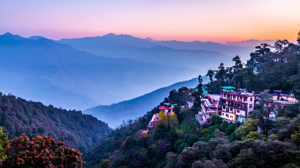 Scenic view of Mussoorie hill station with green mountains and colonial buildings in Uttarakhand.