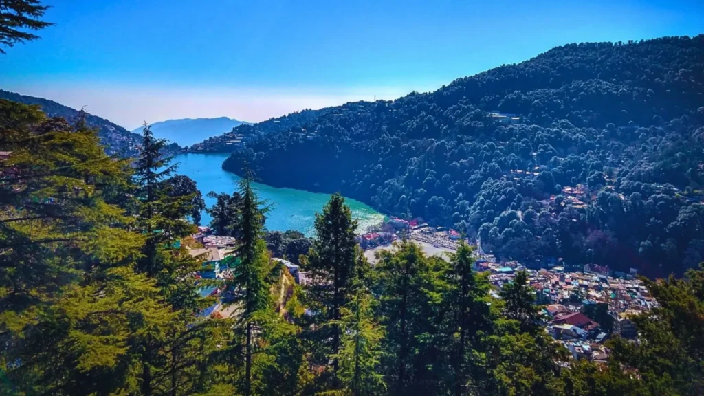 Beautiful Naini Lake surrounded by lush green hills and colorful boats in Nainital.